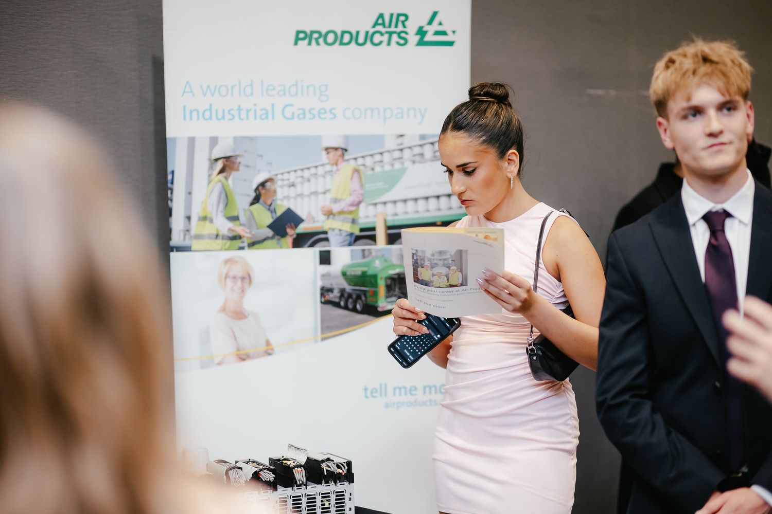 Business professionals review product documentation and marketing materials during a corporate meeting.
