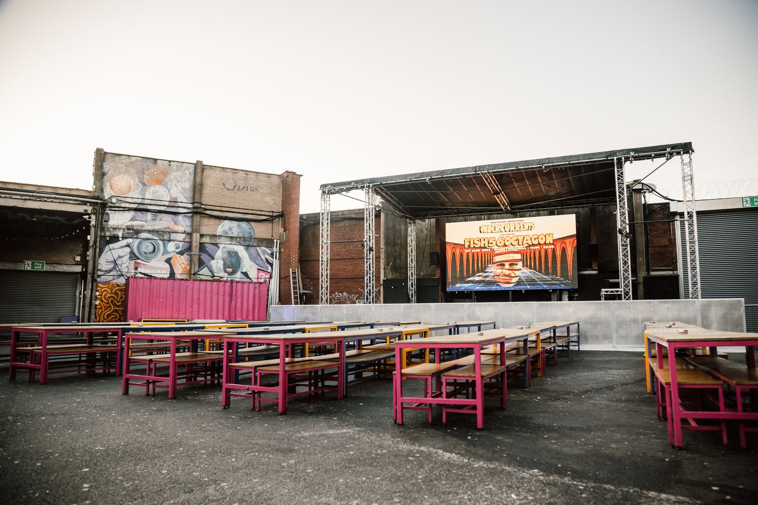 Industrial venue space with pink benches arranged in rows against concrete walls at Luna Springs Digbeth