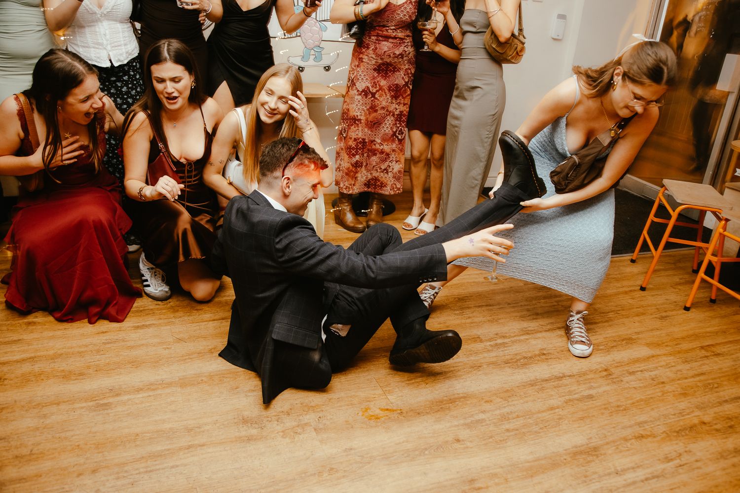 Party guests enjoying themselves on a wooden dance floor at a celebration.