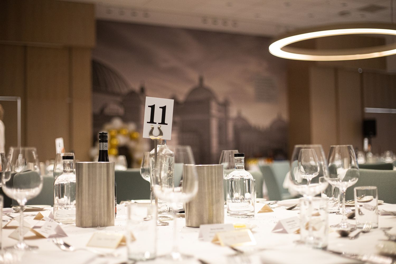 Elegant table settings with wine glasses and place settings in a banquet hall.