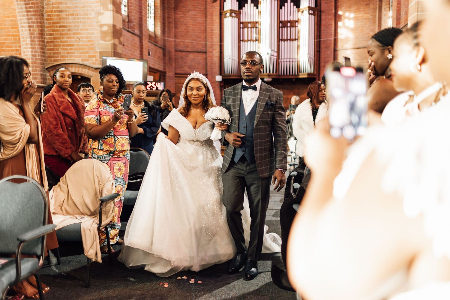 Wedding party members walk down the aisle in a traditional church ceremony.