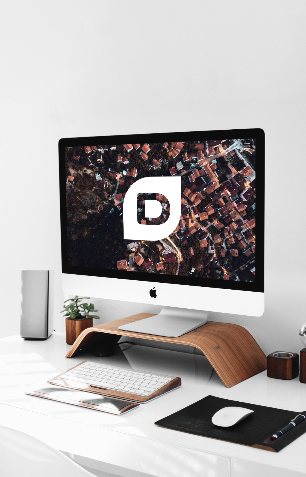 Stylish desk setup with iMac, wooden monitor stand, and minimalist accessories.