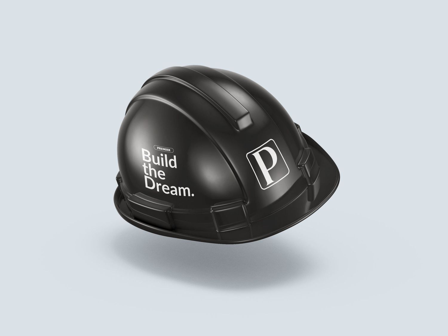 Black construction hard hat with 'Build the Dream.' slogan and P logo, displayed on light blue background.