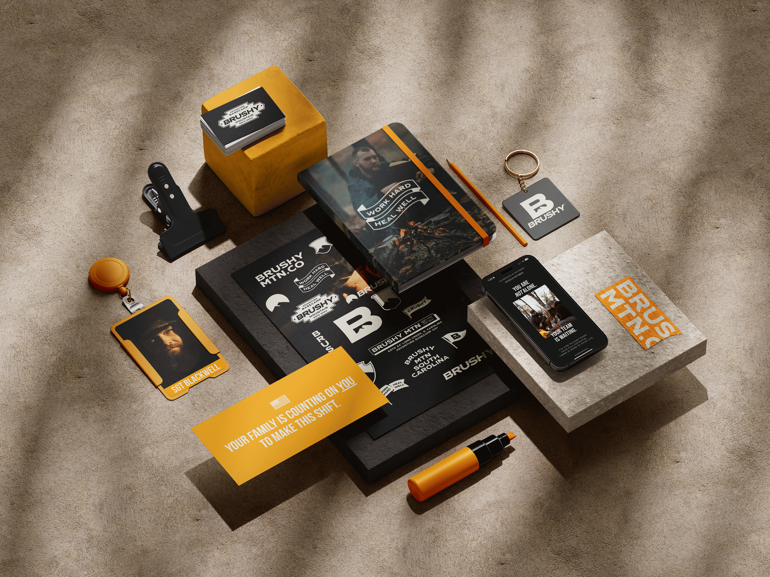 Branded business materials and stationery in black and yellow color scheme arranged on textured surface.