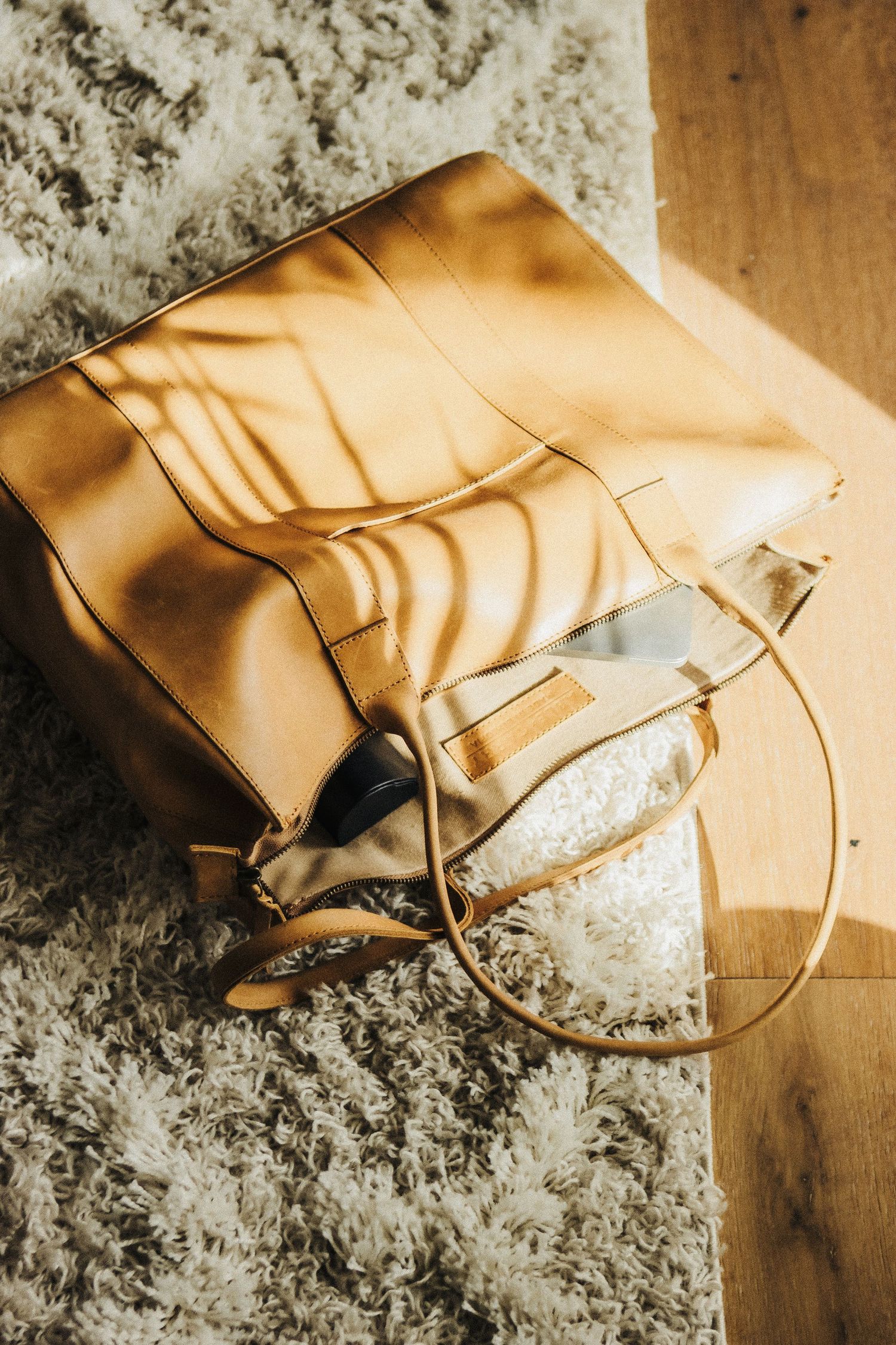 Lifestyle product photo of artisan tote bag with minimalist abstract print on soft neutral rug