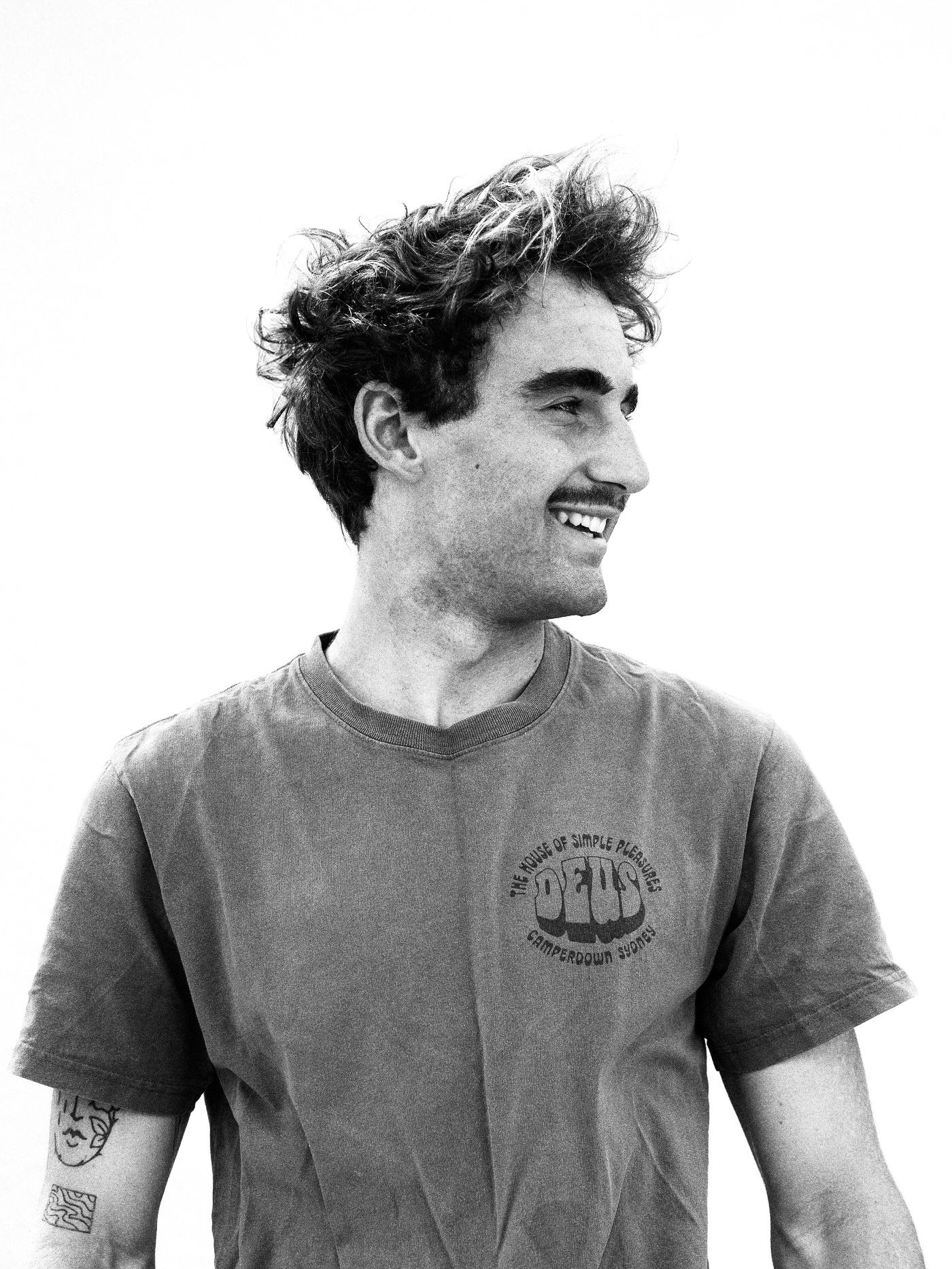 Portrait of a man in a casual t-shirt smiling against a white background.