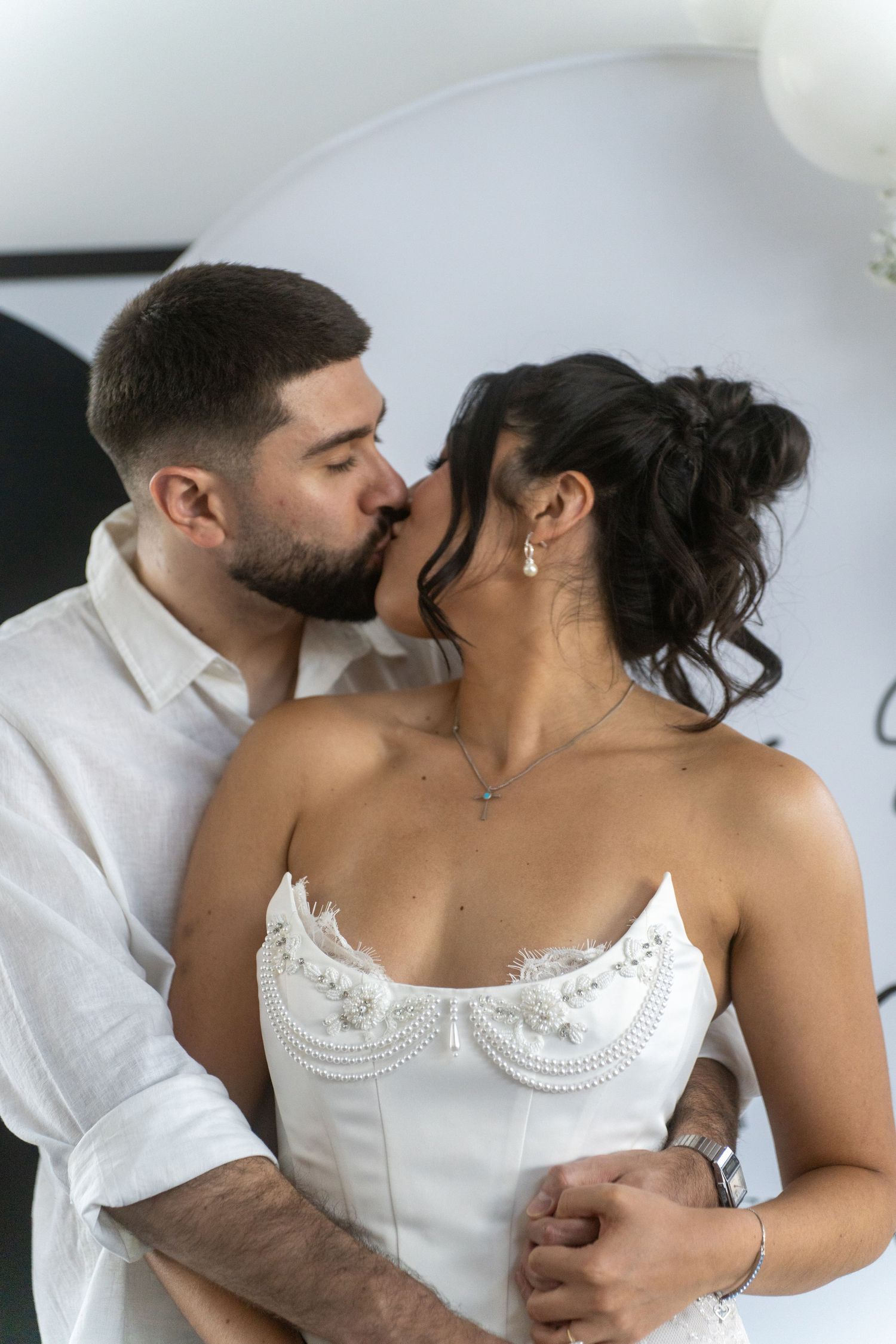 A romantic couple shares an intimate moment, with the woman wearing a white lace corset top.