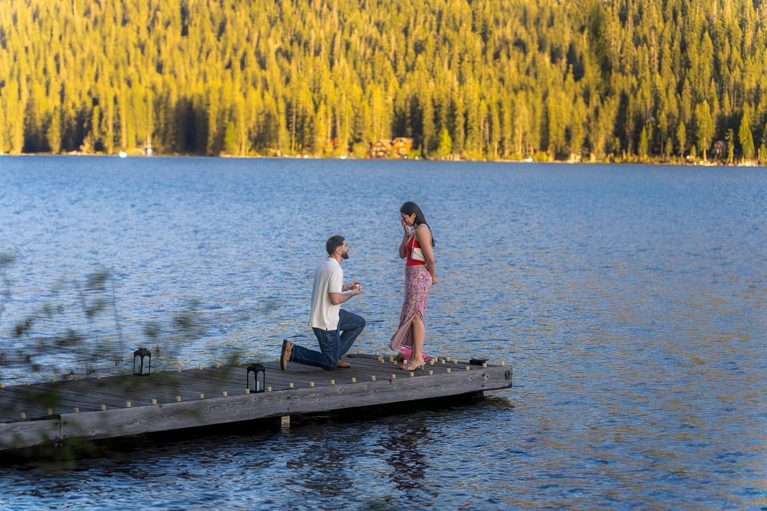 People enjoy a summer day of water sports and recreation at a scenic lake surrounded by golden autumn trees.