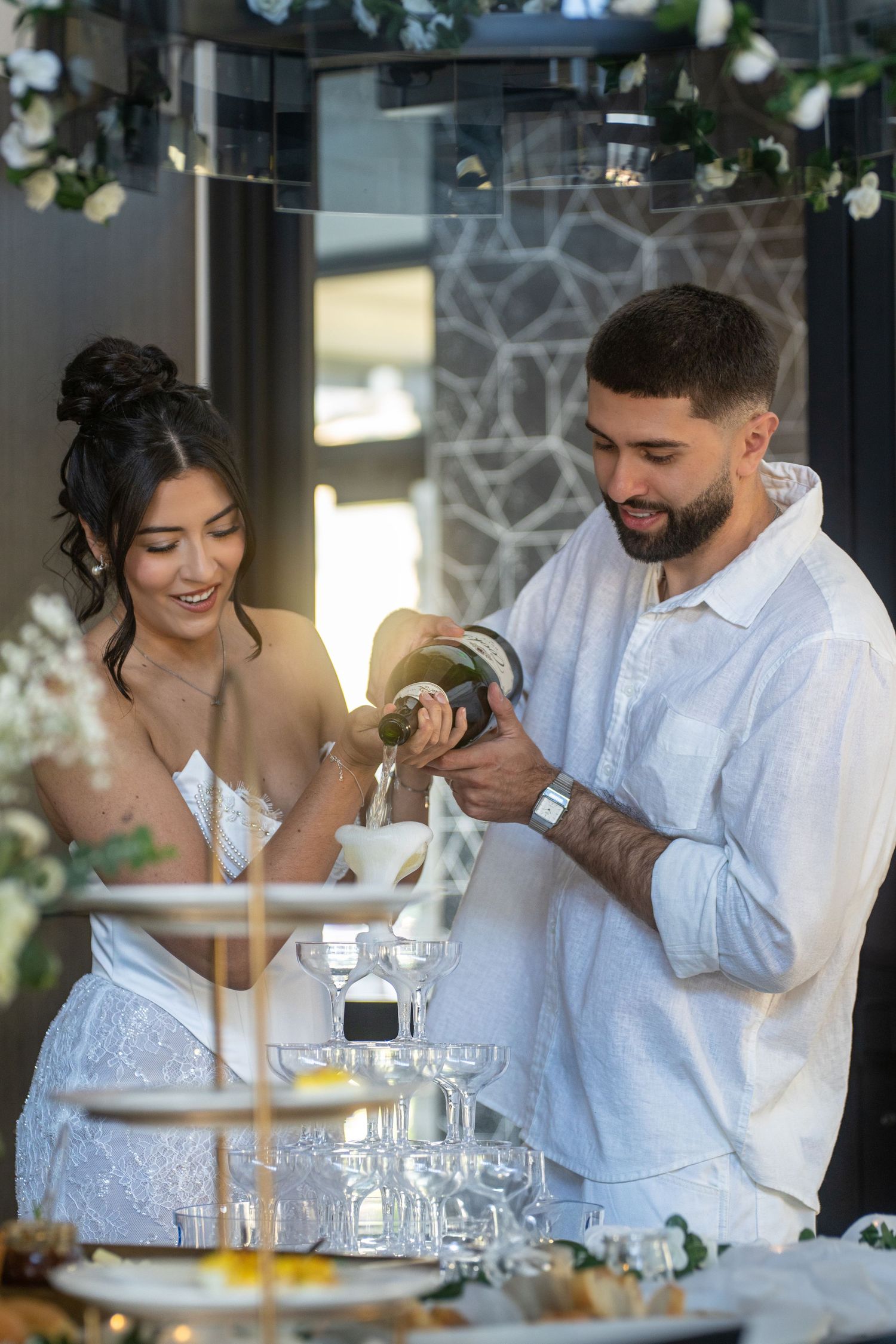 Couple sharing laughter and intimate moments while dining together at an elegant restaurant table with wine glasses.