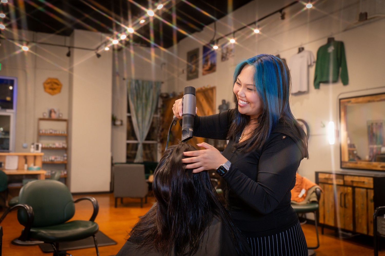 Hair stylist working on client's hair in modern salon interior.