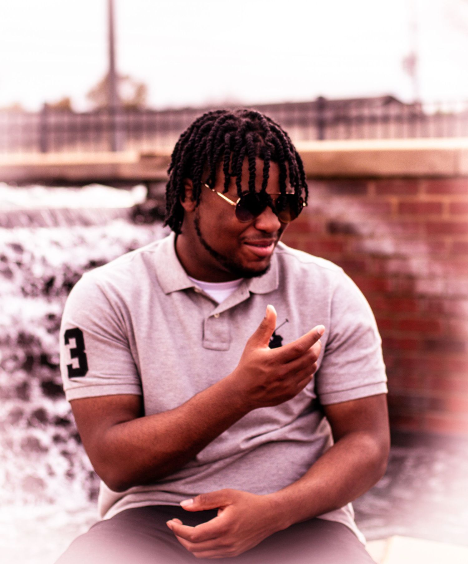 Casual outdoor portrait in grey polo shirt with sunglasses.