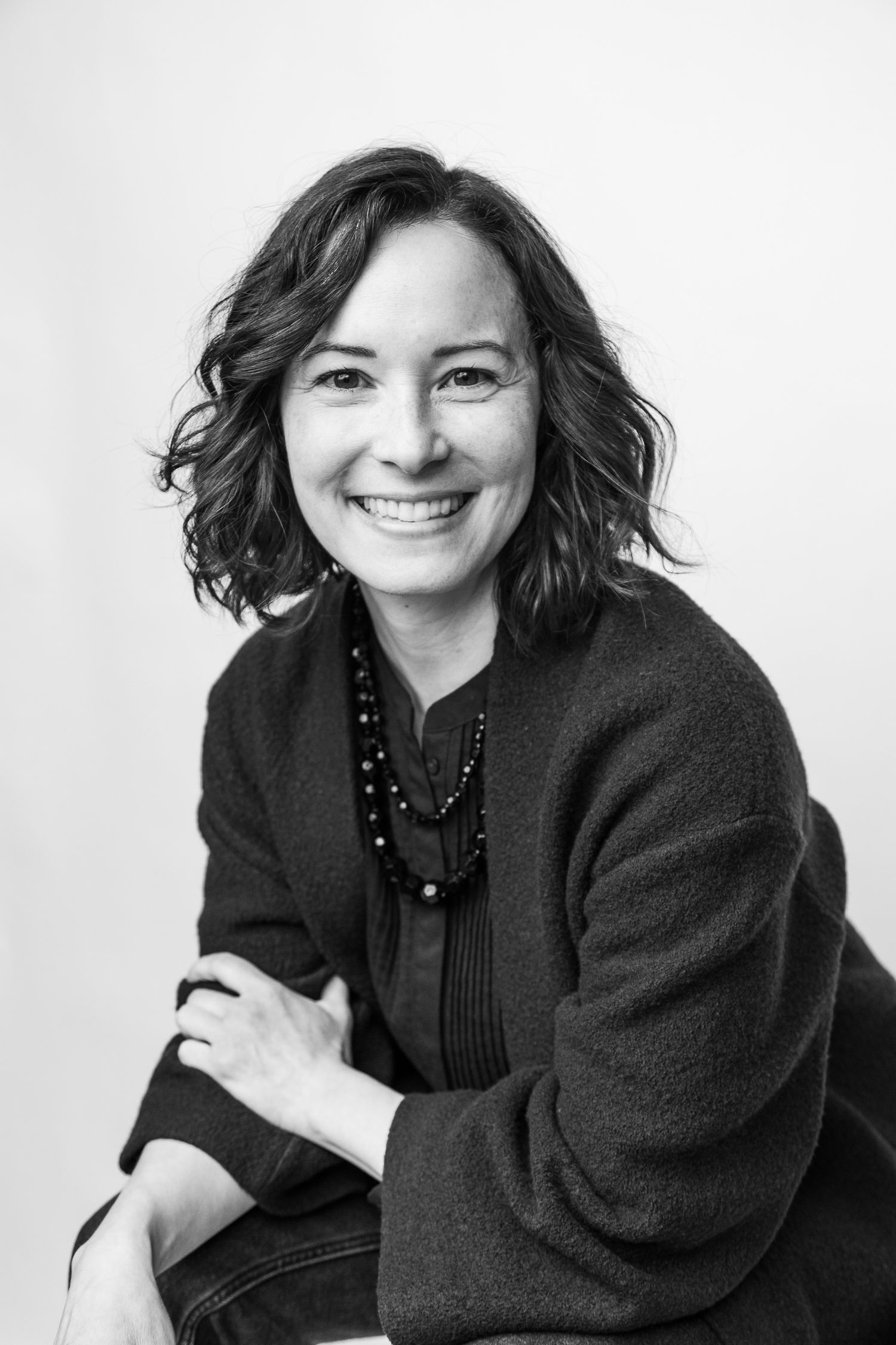 black and white portrait of a smiling confident woman looking straight at the camera