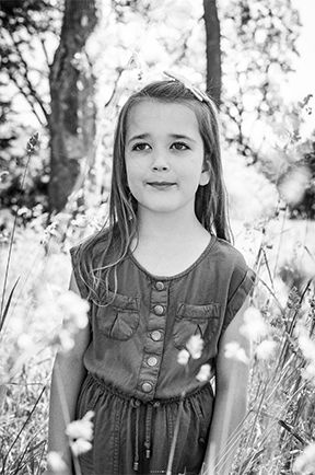 Portrait of a girl standing in among the flowers
