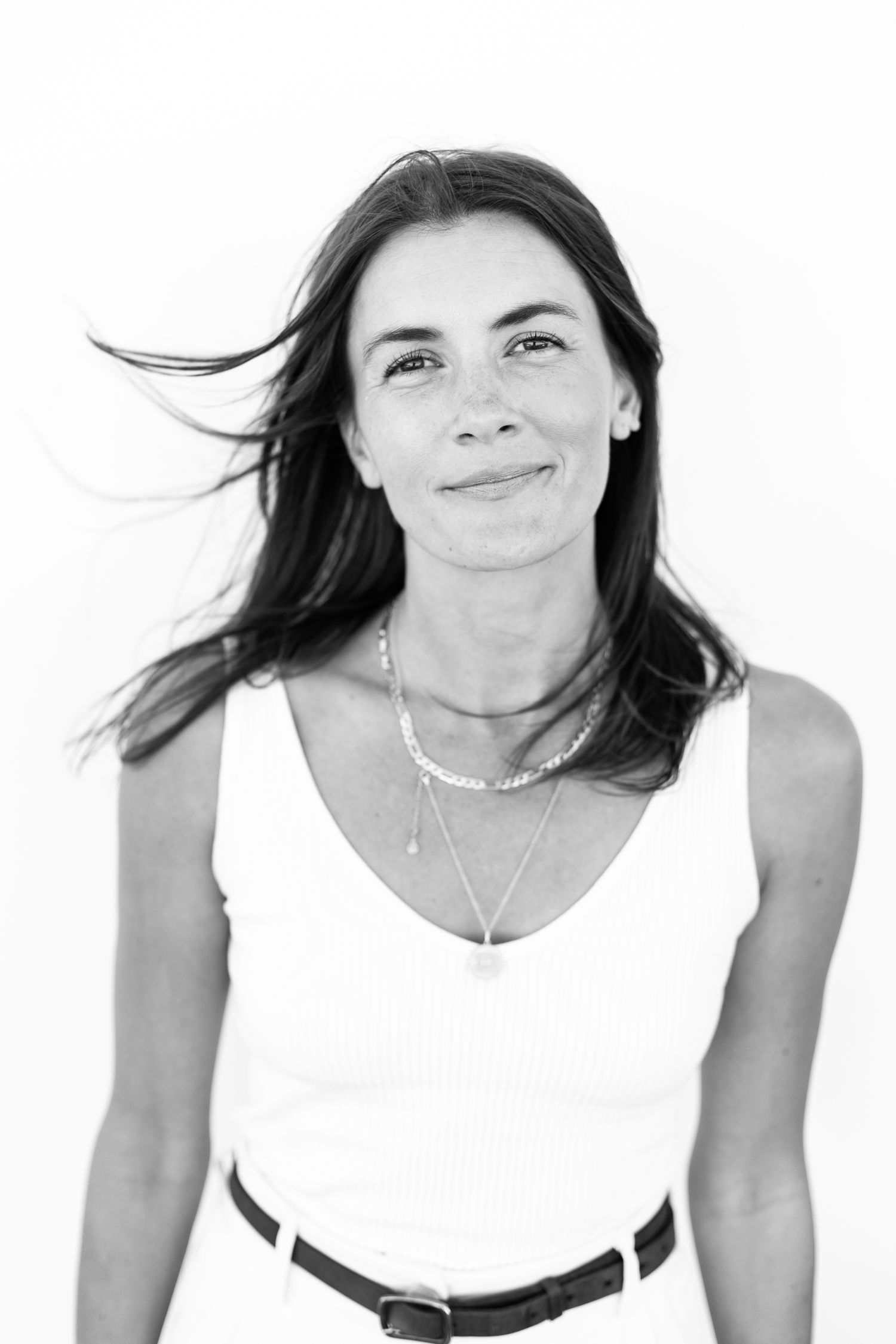 Black and white photo of chic brunette woman with wind blowing through her hair