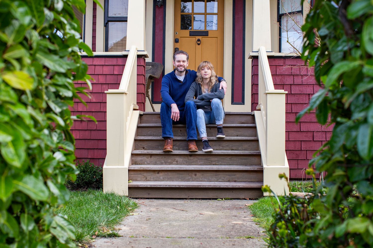 twenty something couple sitting on the steps of their heritage home
