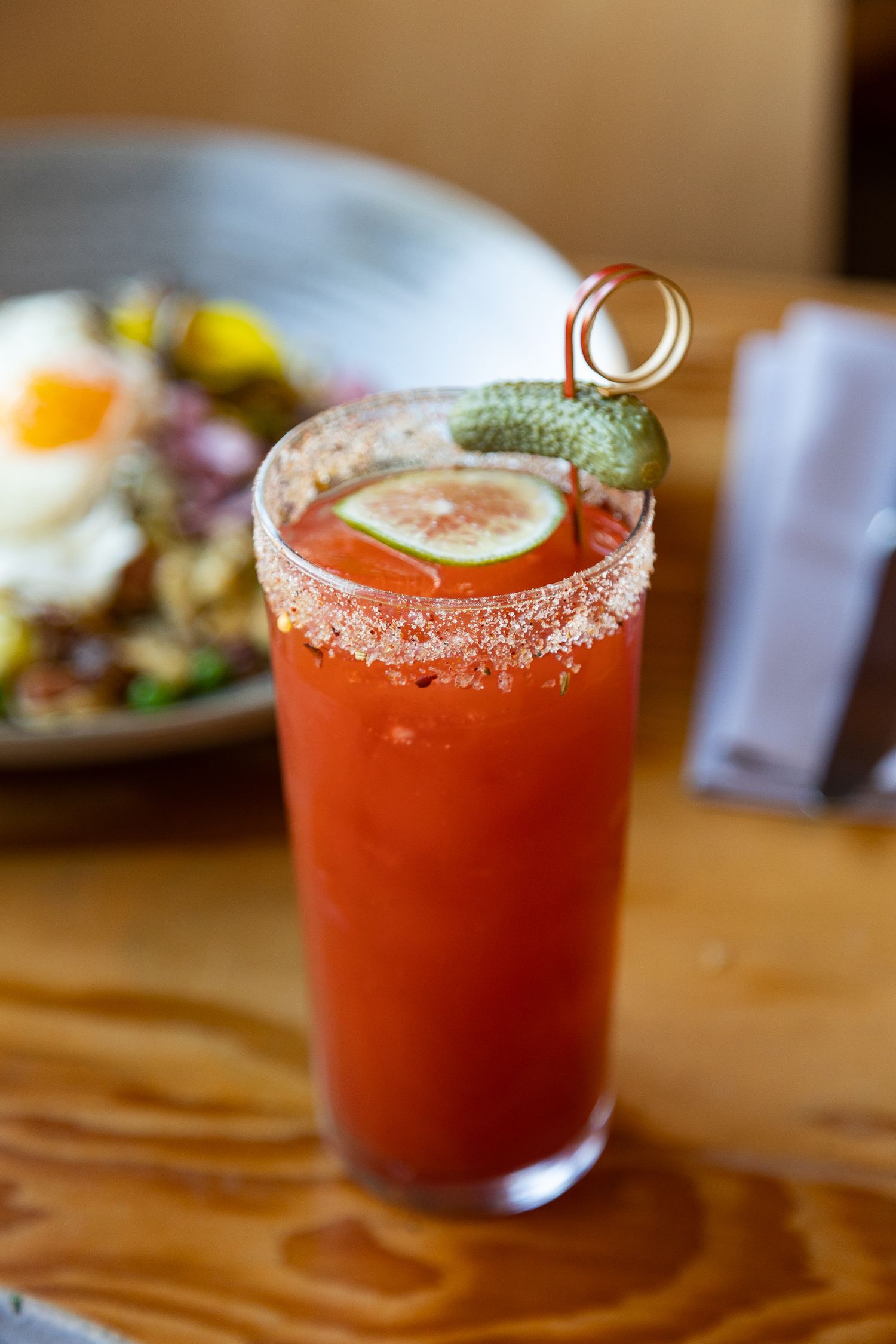 A Ceasar drink with a lemon and pickle garnish