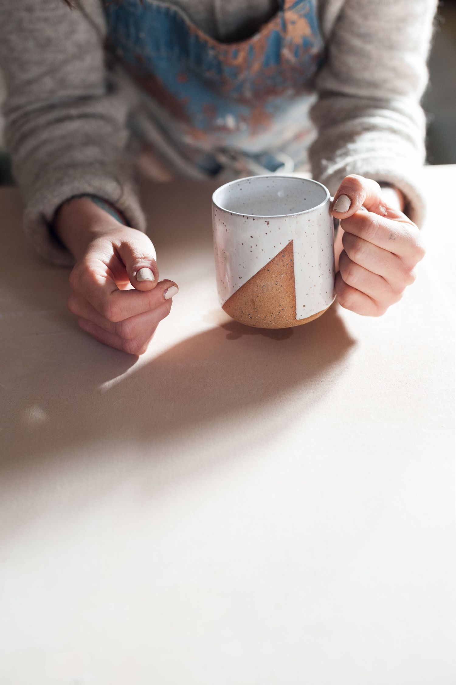 close up image of womans hands holding a coffee cup