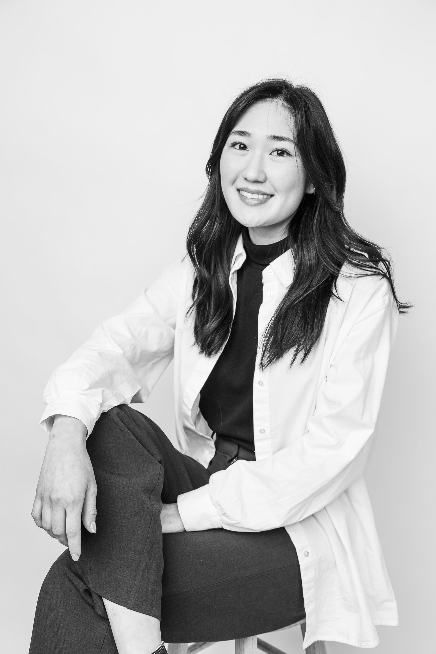 black and white portrait of a smiling confident woman looking straight at the camera