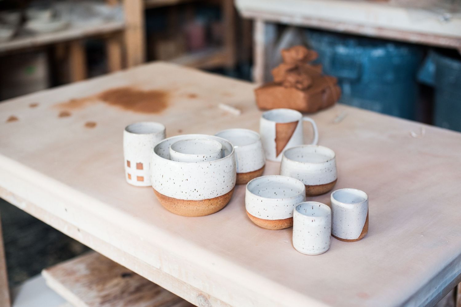 collection of ceramics on a table in a ceramics studio