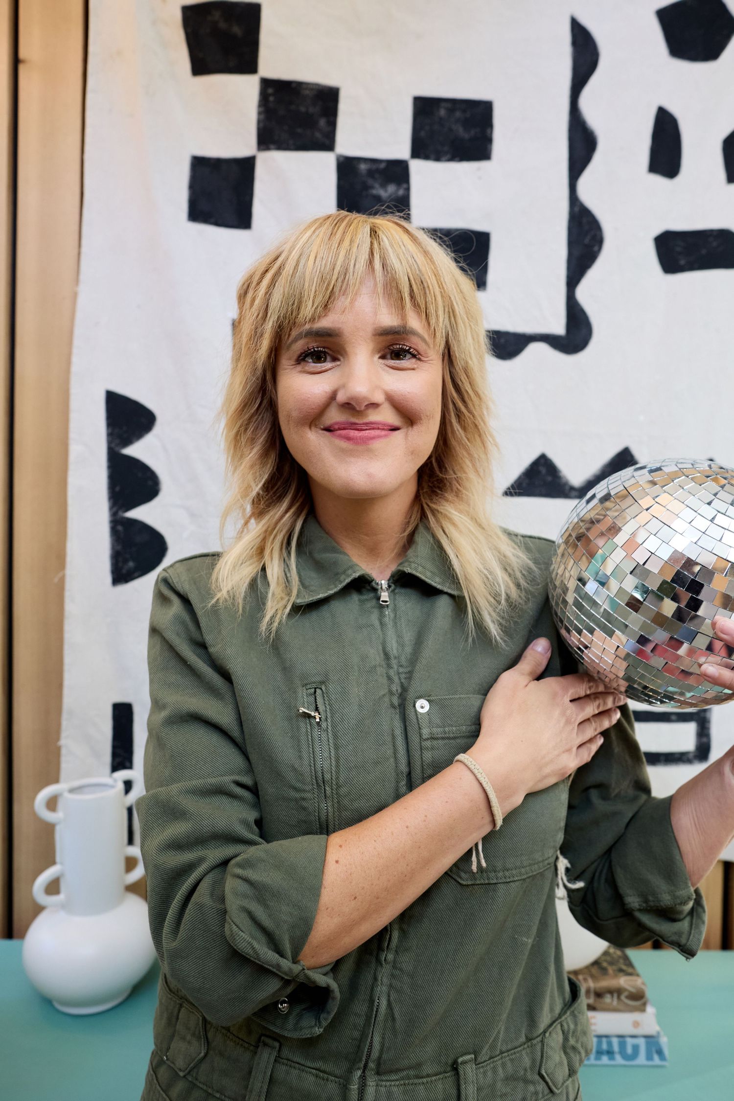 woman with stylish blonde hair holding a disco ball