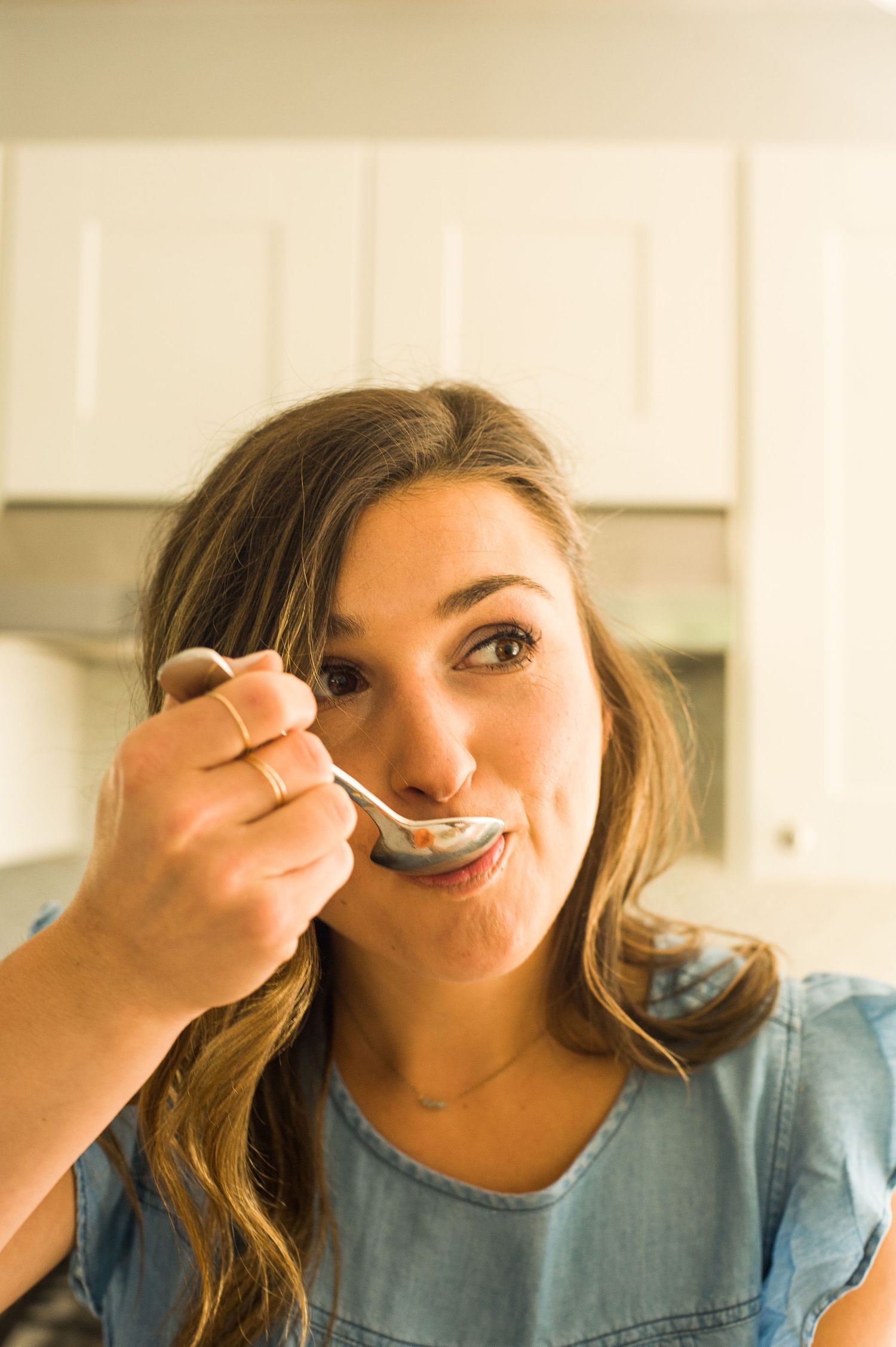 A woman putting a spoonful of food into her mouth