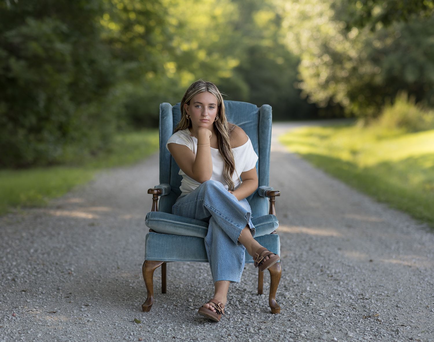 High school senior girl sitting in a chair on a country road in Central Illinois