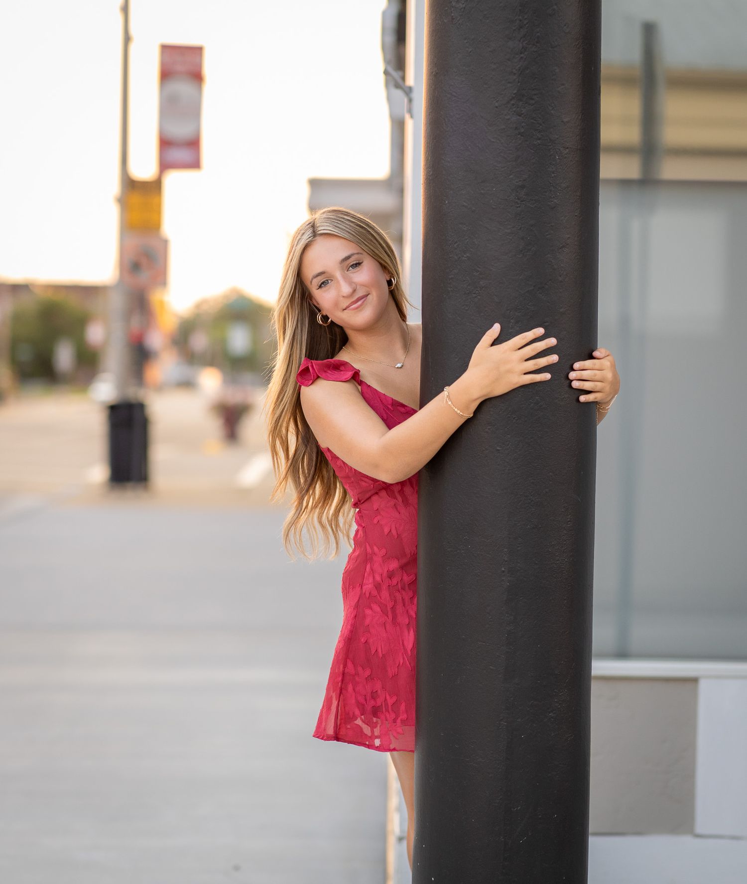 High school senior girl in red dress posing outdoors in Central Illinois
