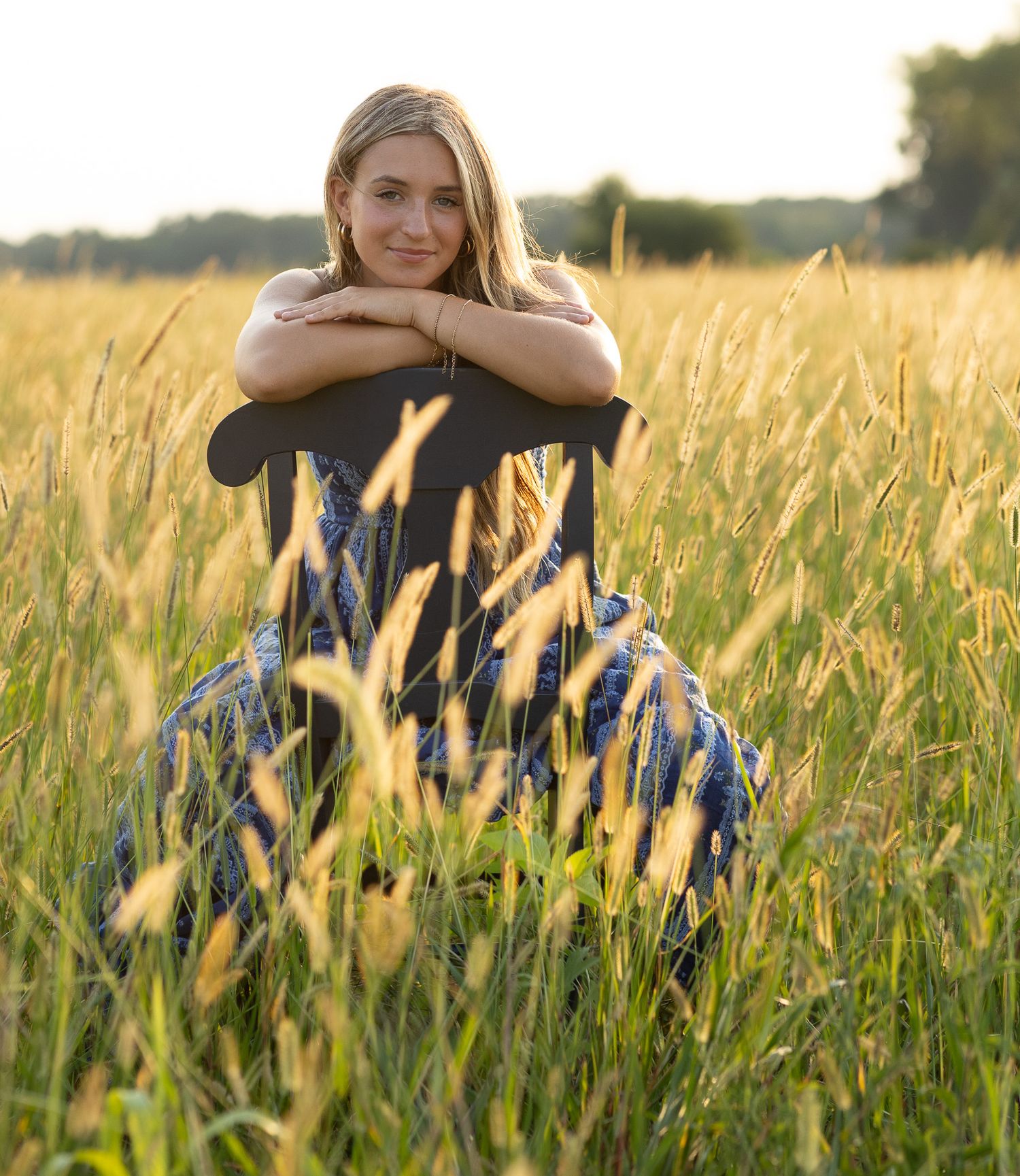 High school senior girl sitting in a field during a Central Illinois senior photography session
