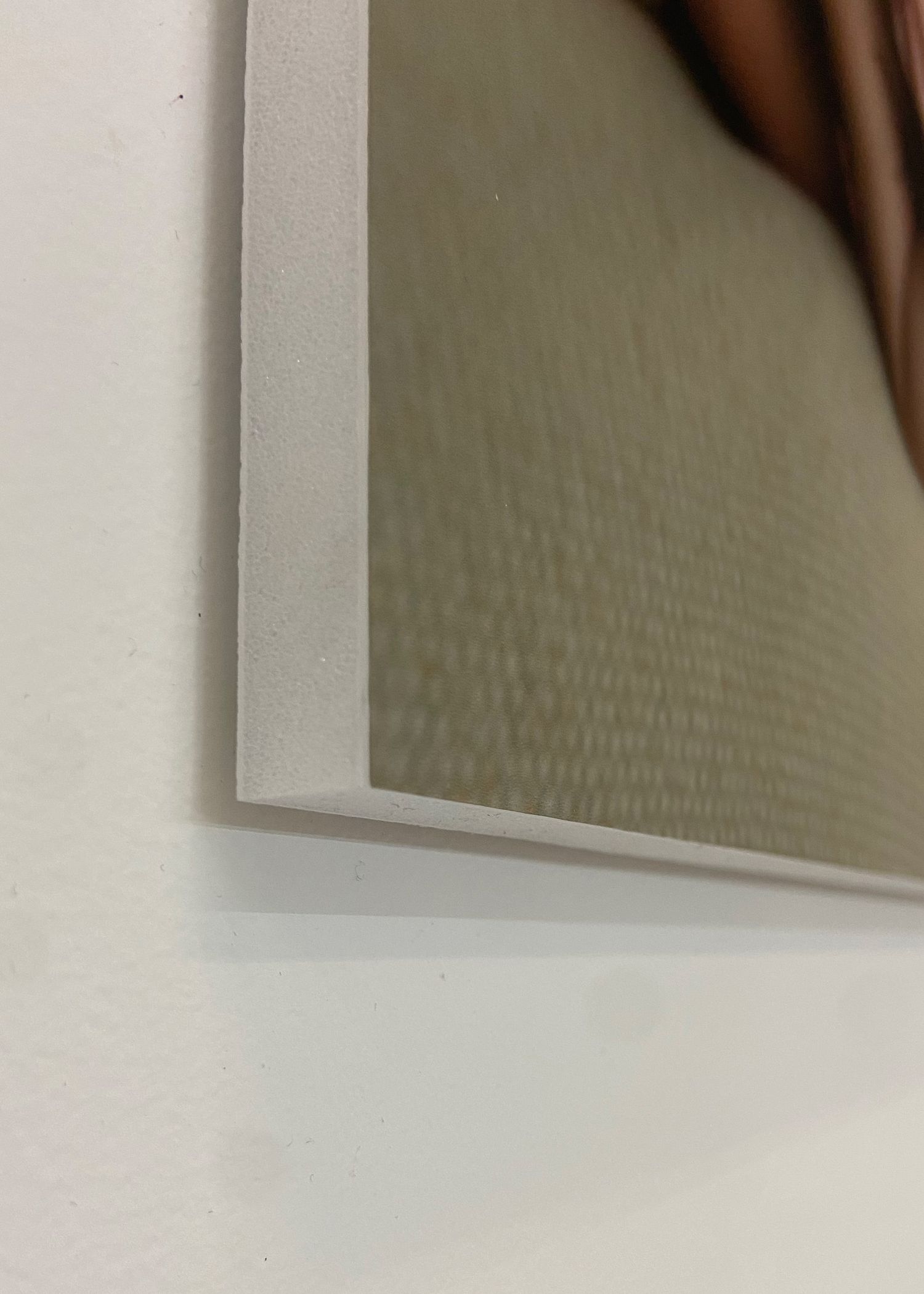 Close-up corner detail of a framed photo print with white border mounting.
