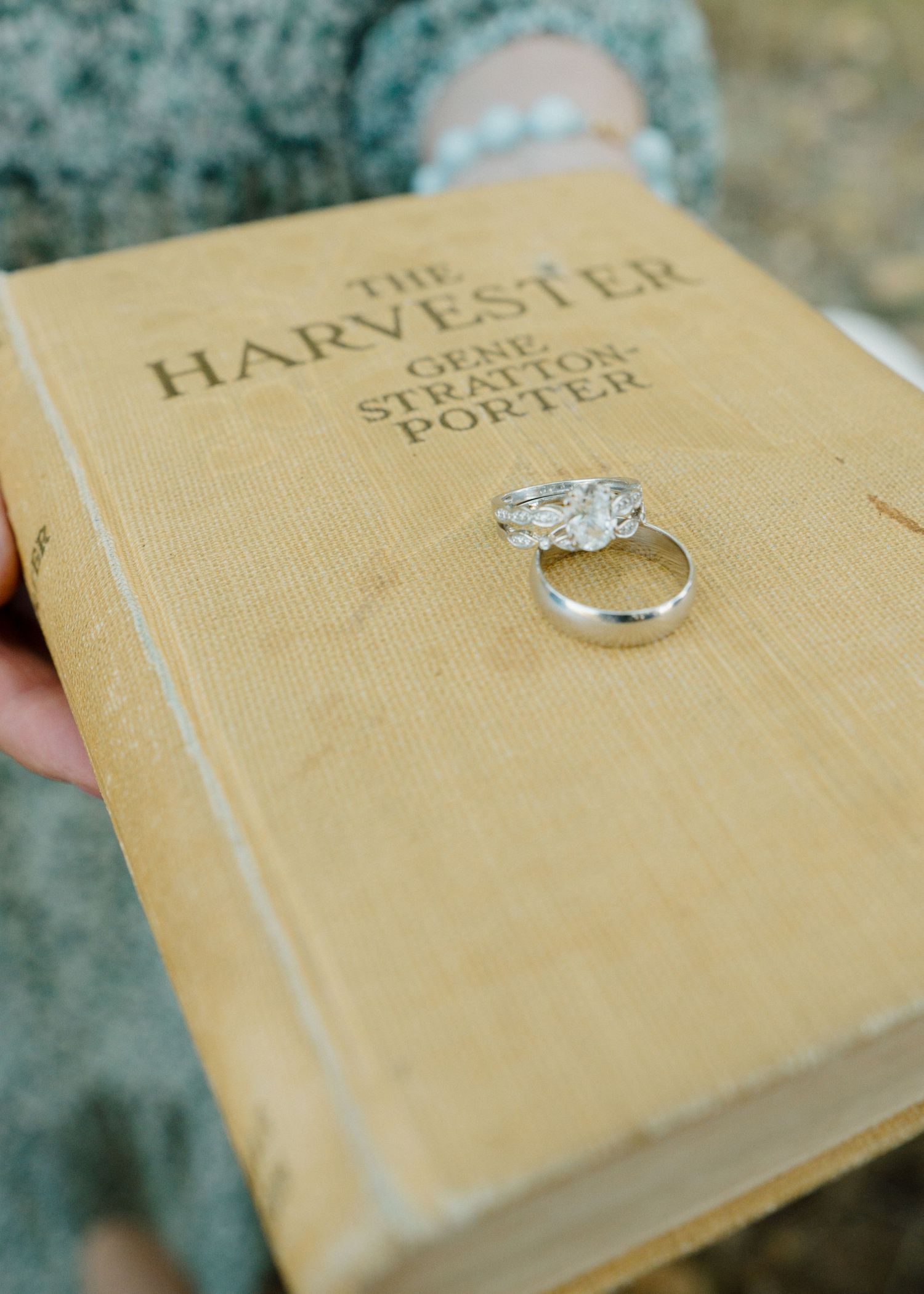 Diamond engagement ring resting on a vintage copy of The Harvester by Gene Stratton-Porter book.