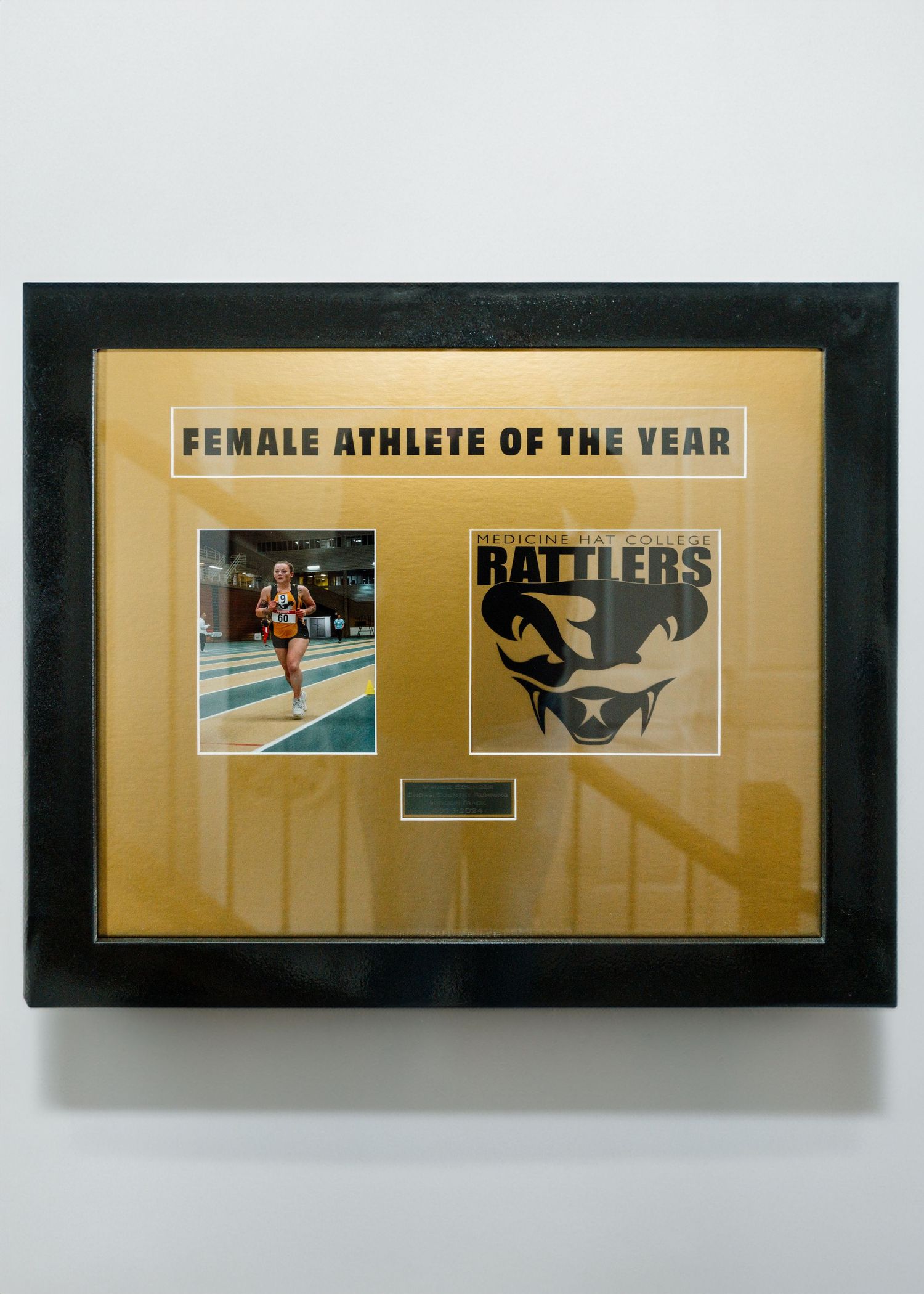Female Athlete of the Year award display featuring runner photo and Rattlers logo on gold mat.