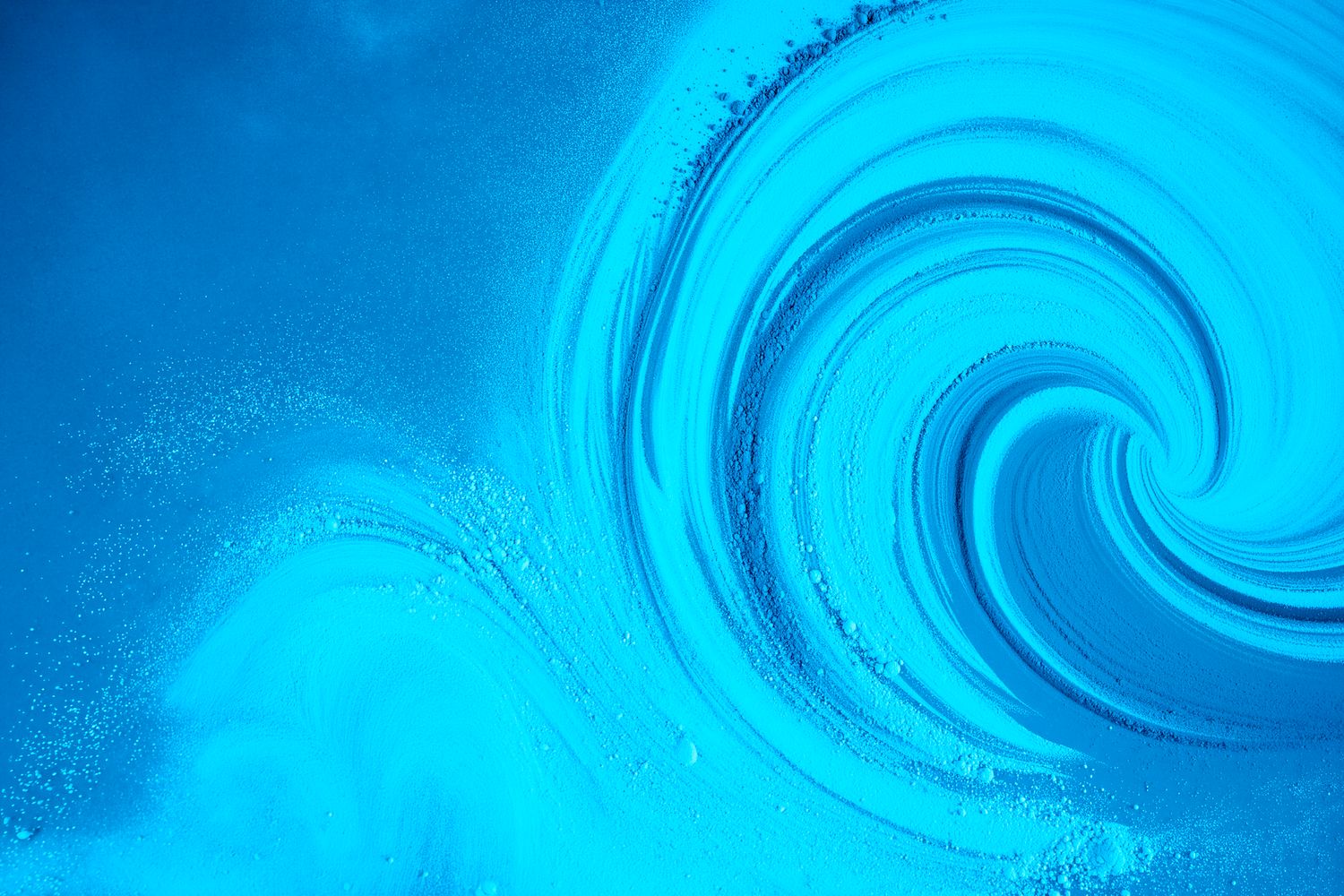 A vibrant blue swirling vortex of water creating a mesmerizing spiral pattern with light reflections.