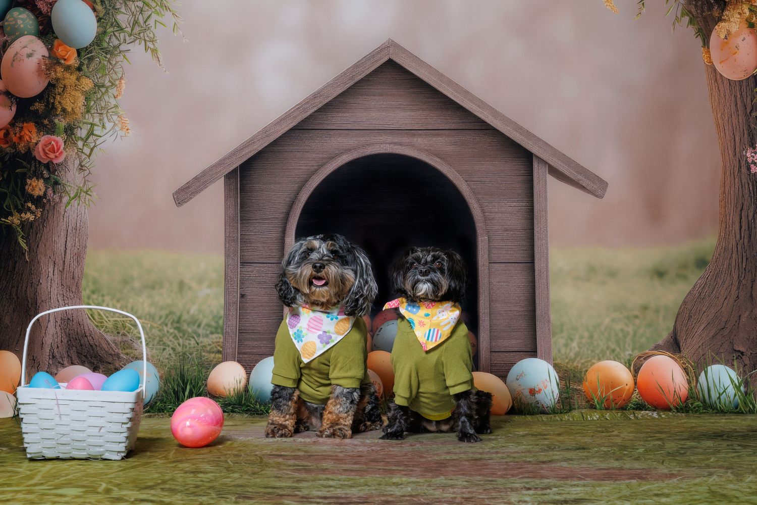 Two dogs in green outfits sit in a doghouse surrounded by colorful Easter eggs and a basket in a festive spring scene.
