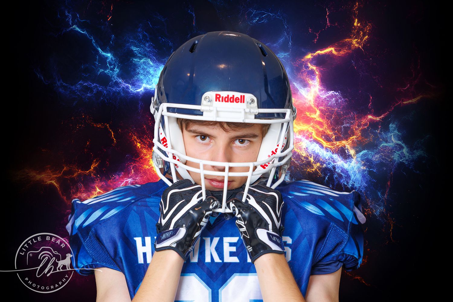 Youth football player in blue Riddell helmet poses against dramatic fire and lightning background.