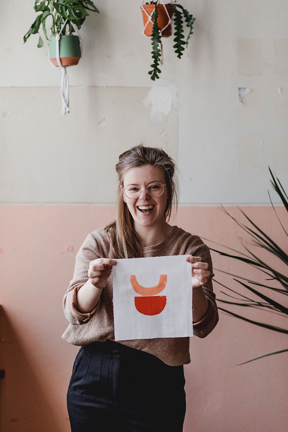 Creatieve onderneemster met kunstwerk tijdens een brandingshoot in een atelier in Breda.