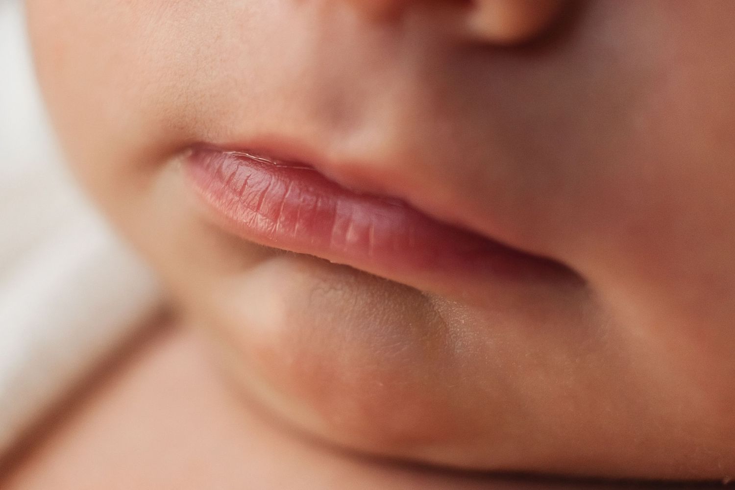 An intimate and soft-focus close-up of a newborn baby’s face, capturing the peaceful and quiet beauty of a sleeping infant.