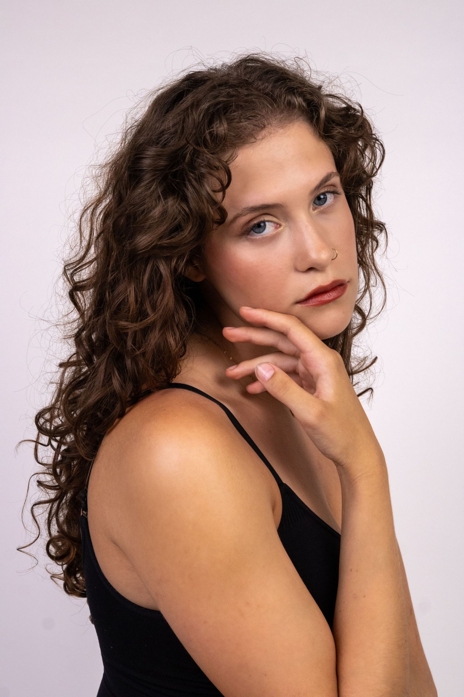 Retrato de uma mulher de cabelo encaracolado, olhando para a câmara.