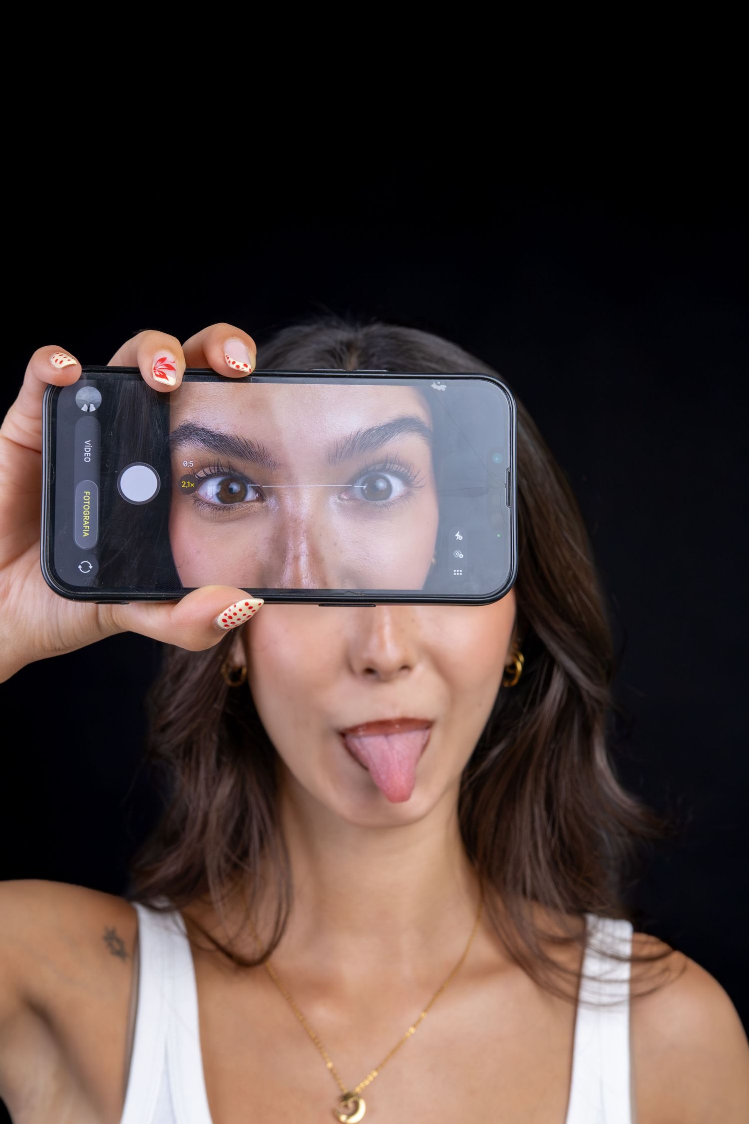 Mulher a segurar um telemóvel à frente do rosto, fazendo uma expressão divertida.
