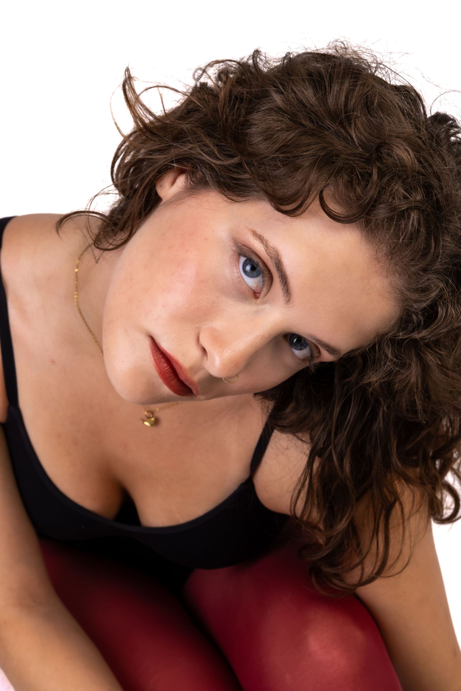 Retrato de uma mulher de cabelo encaracolado, sentada.