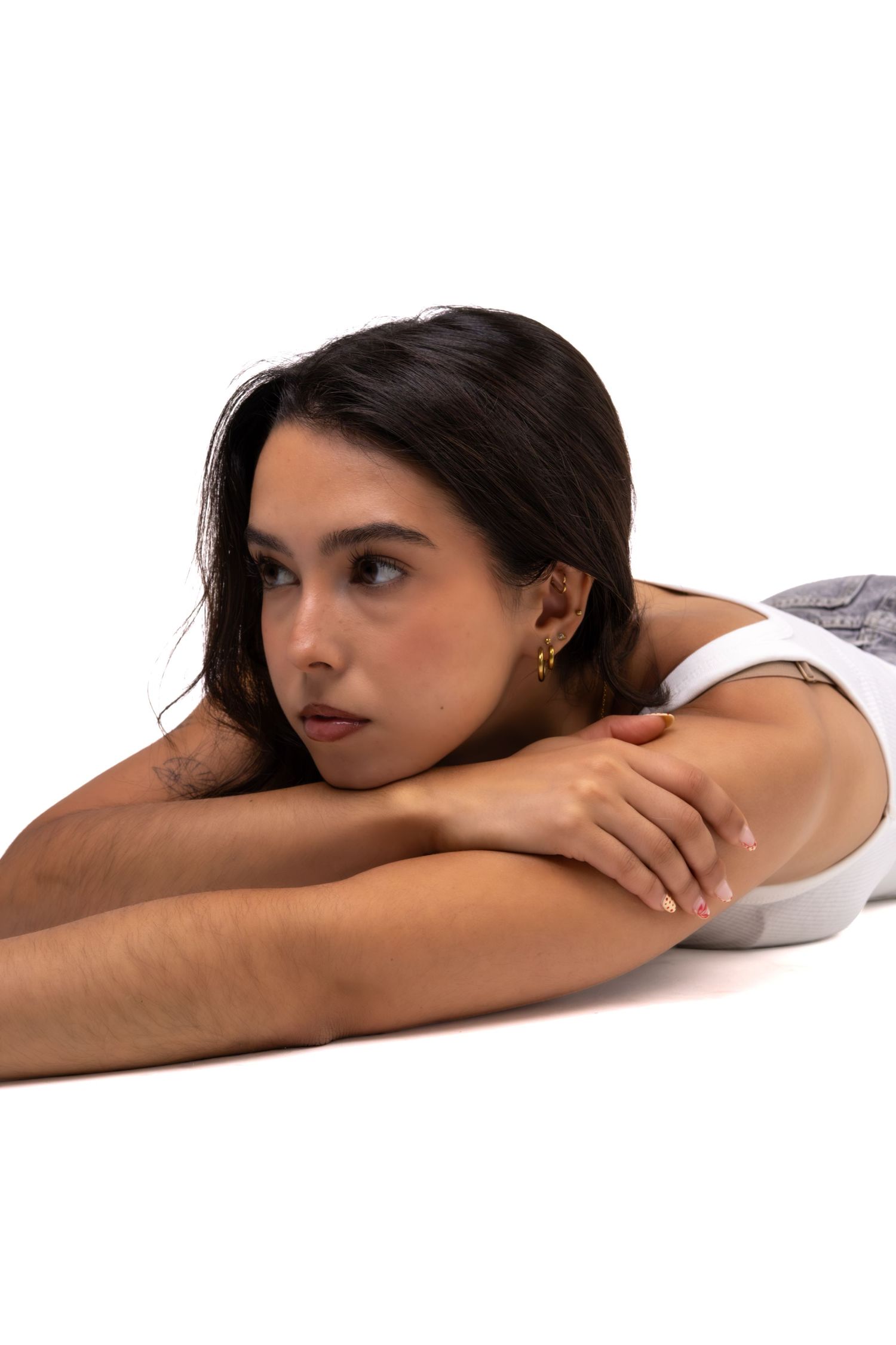 Retrato de uma mulher deitada sobre os braços, num fundo branco.
