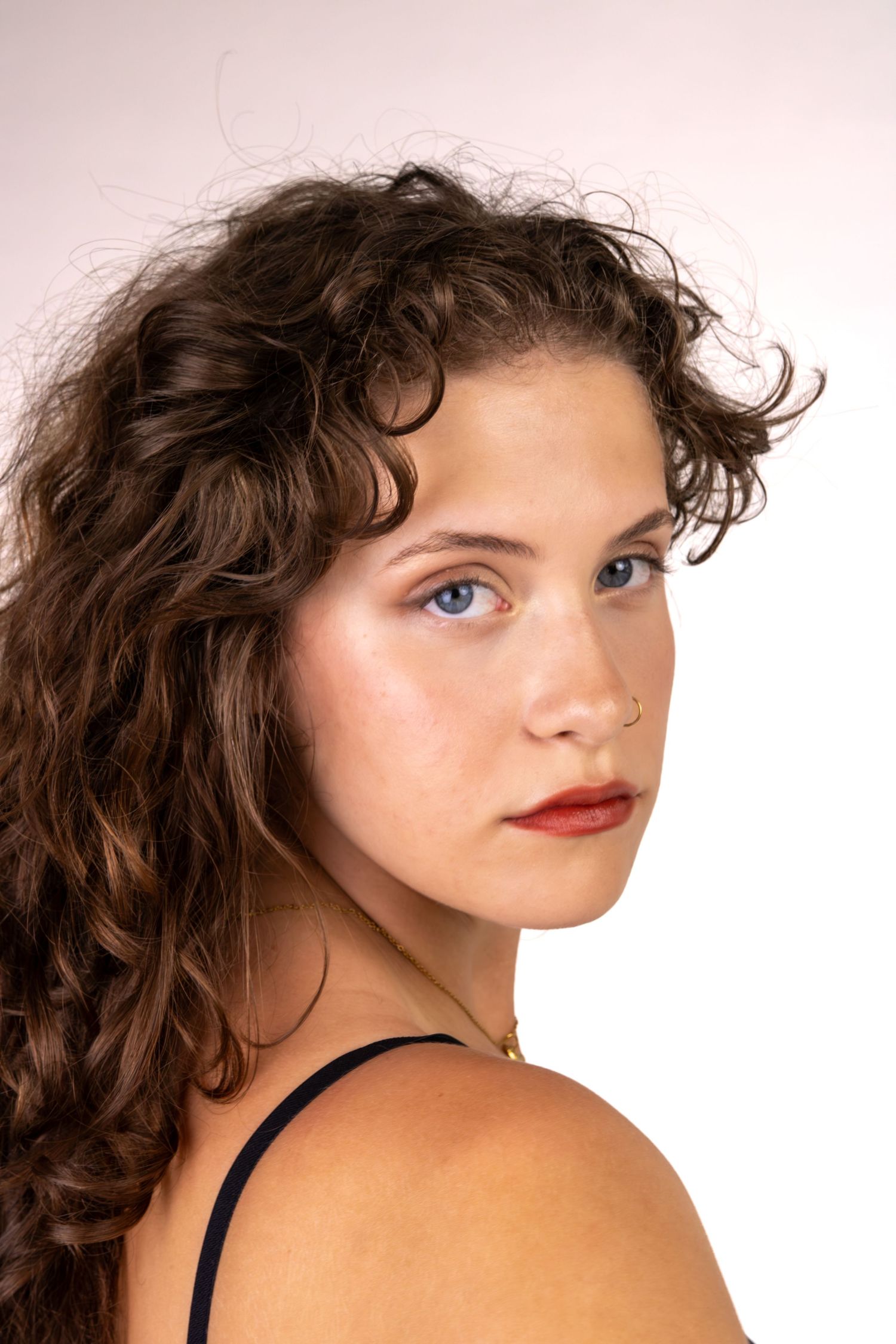 Retrato de uma mulher de cabelo encaracolado, de perfil.