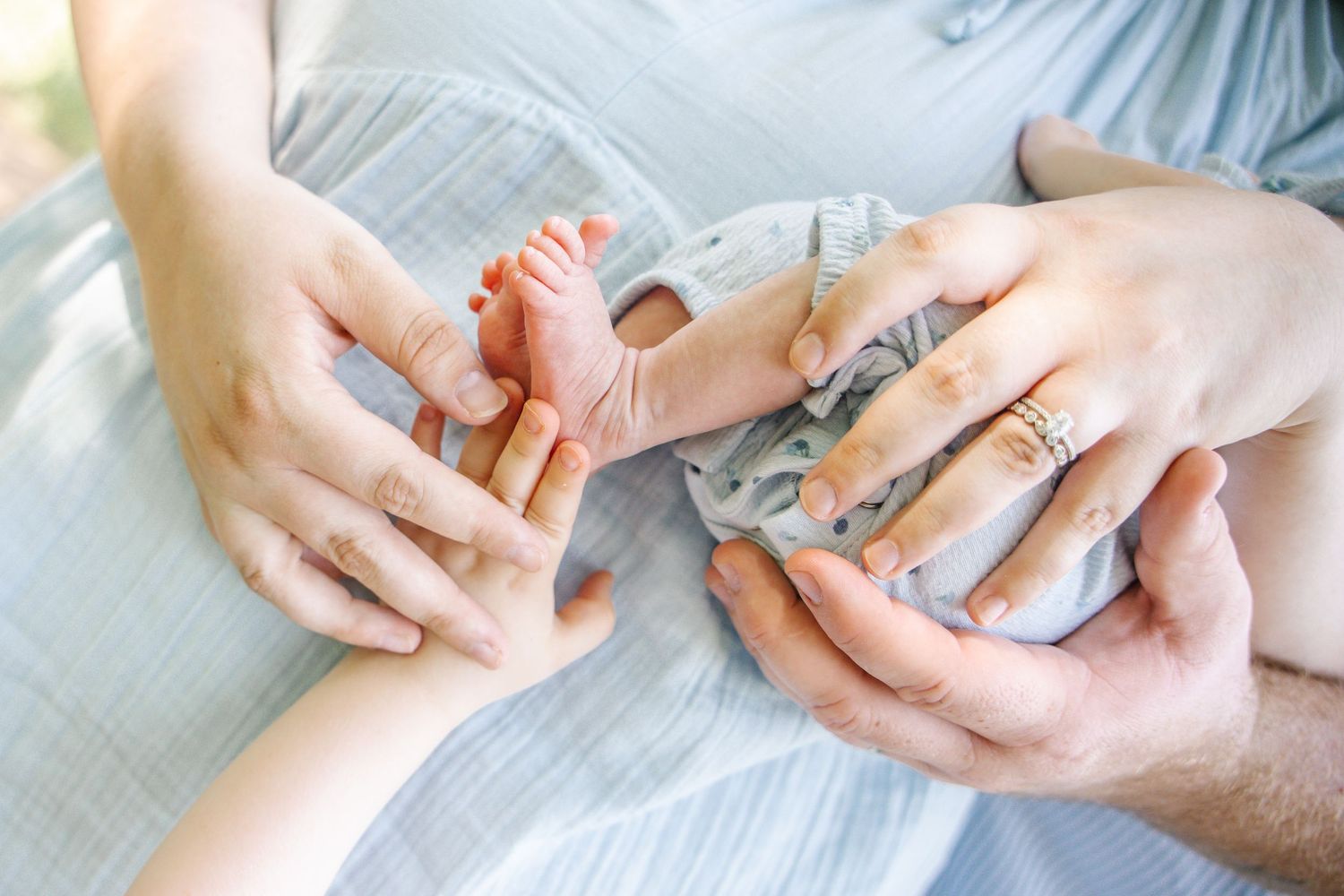 Close-up of parents hands tenderly holding newborn baby feet, symbolizing love and new parenthood.