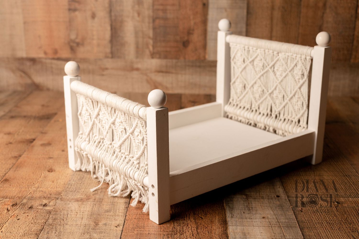 White wooden miniature boho bed with macrame details, perfect for newborn photography props.