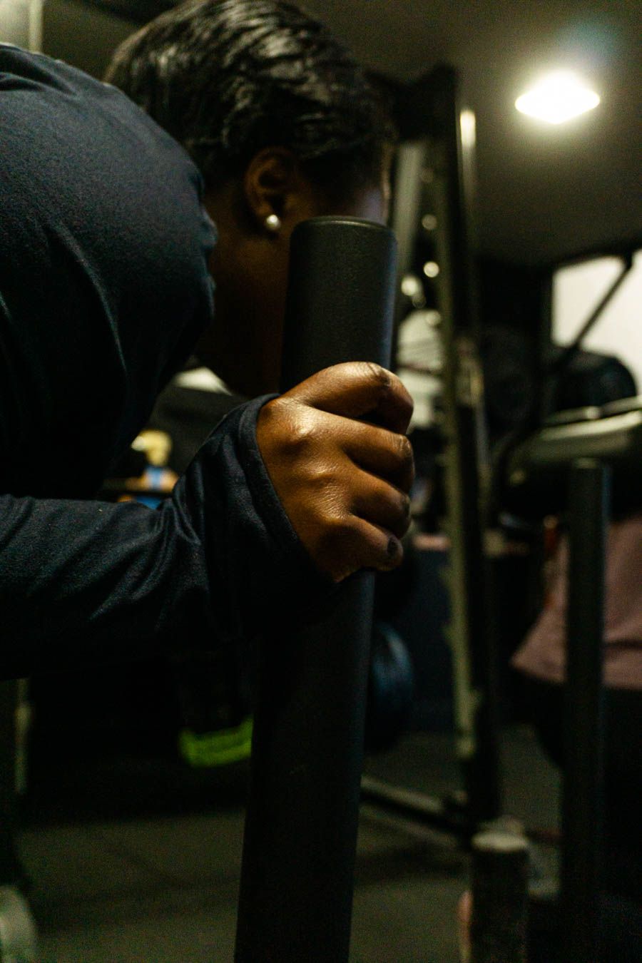 Close-up of person gripping metal gym equipment handle during exercise session.