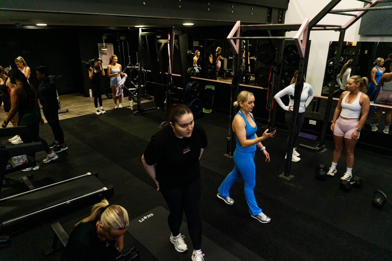 Women participating in a group fitness session in a dark gym.