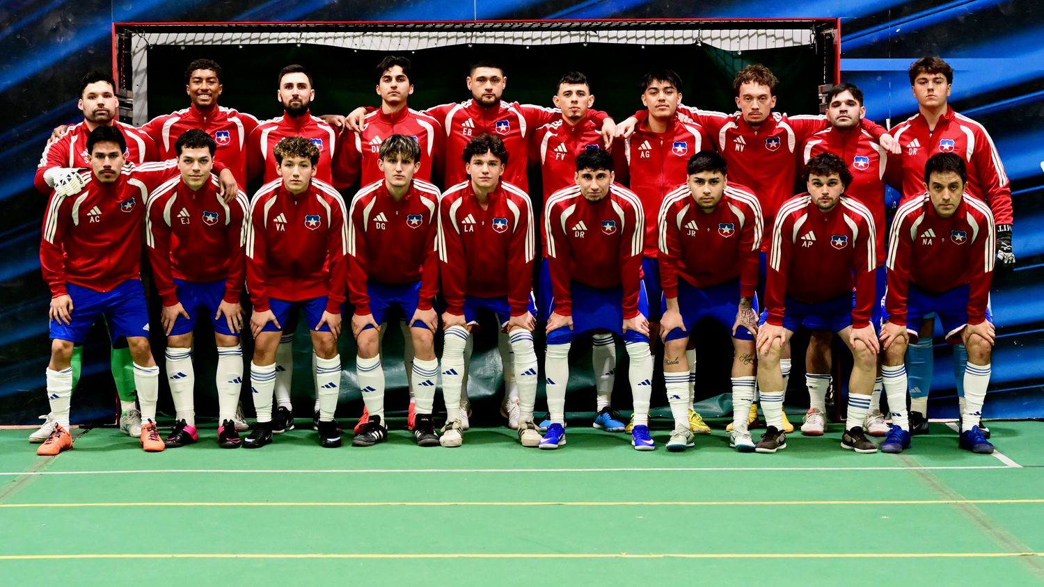 Chile youth futsal team poses for group photo in red uniforms indoors.
