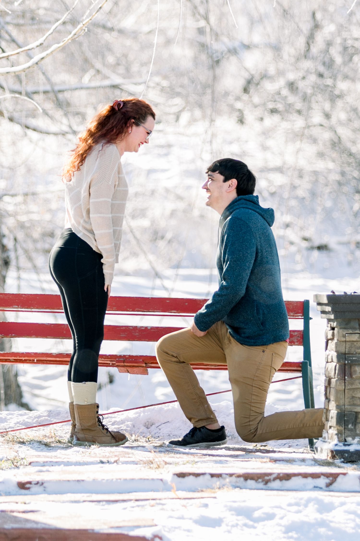 A woman being proposed to by her boyfriend in the snow