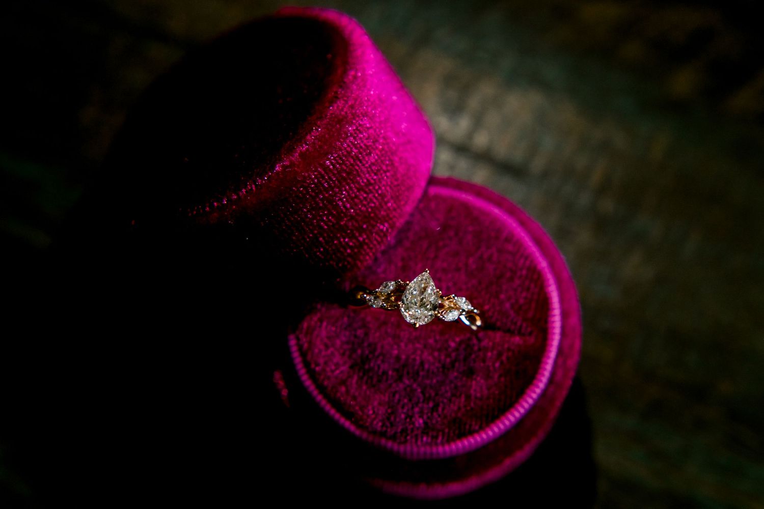 A pear cut engagement ring in a pink velvet ring box