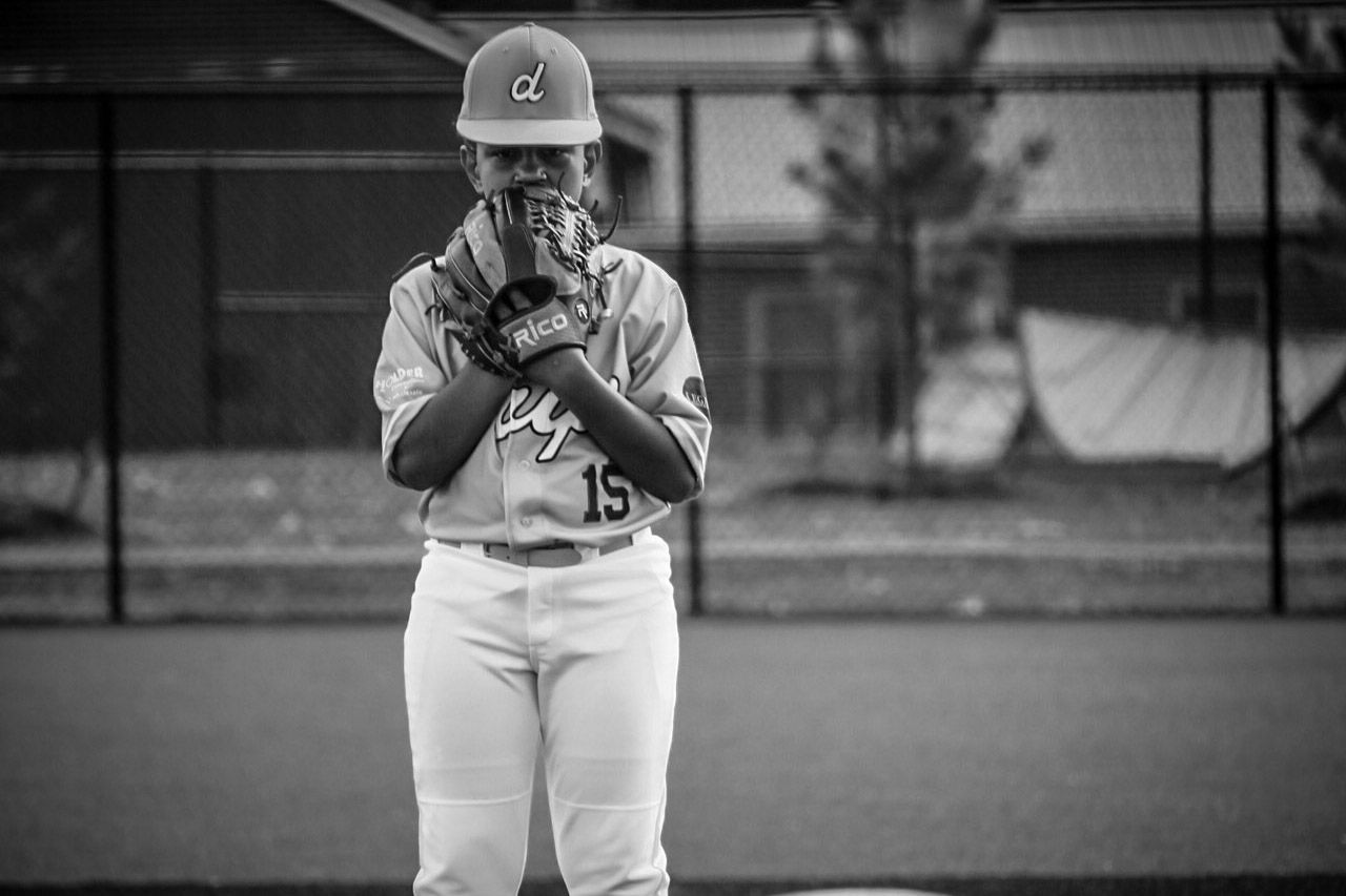Black and white photo of a baseball pitcher in uniform standing on the mound.