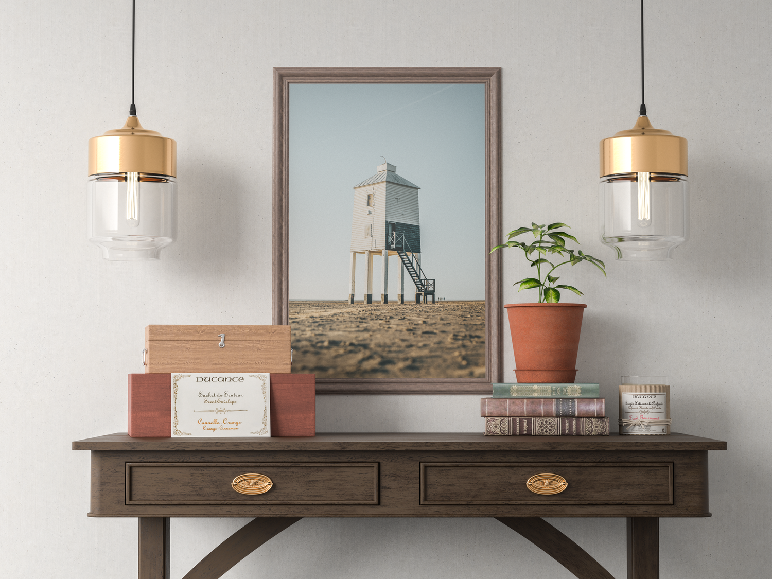 Framed coastal lighthouse photograph on rustic wooden console table with books and plant.